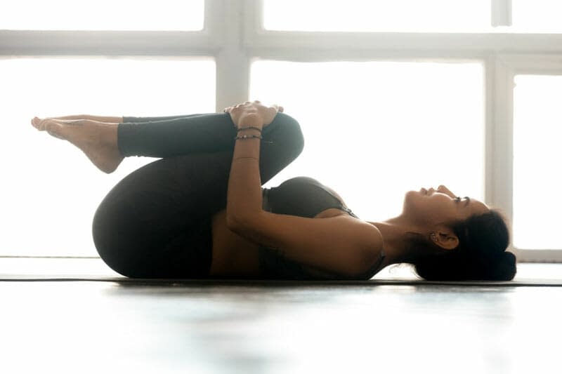 Knees-to-Chest Pose (Apanasana)- 9 Yoga Poses that Relieve Menstrual Cramps (With Variations)